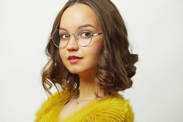close-up portrait of woman with short wavy hair in round spectacles over white isolated. - Foto, afbeelding