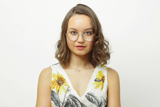 Isolated portrait of cute woman with short hair under shoulders, wearing round spectacles, has a serious and calm expression. - Foto, Imagen