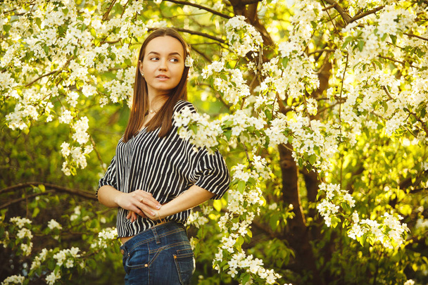 young woman with clean skin near a blooming apple tree. portrait of girl in spring park. - Fotografie, Obrázek