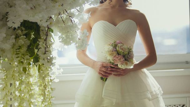 Attractive model in wedding dress with brides bouquet - Zdjęcie, obraz