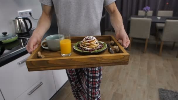 Sección media del hombre con bandeja de desayuno caminando
 - Metraje, vídeo