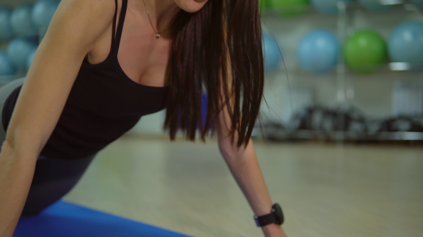 Έννοια ενός υγιεινού τρόπου ζωής. Νεαρή γυναίκα κάνει ασκήσεις σε ένα χαλί γυμναστήριο - Πλάνα, βίντεο