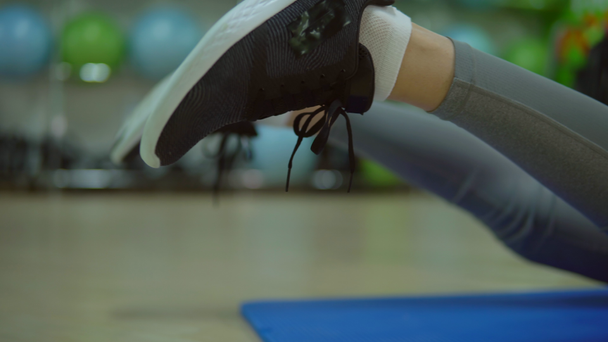 Νεαρή γυναίκα να κάνει ασκήσεις για την πλάτη σε ένα στρώμα γυμναστικής. Γυμναστήριο - Πλάνα, βίντεο