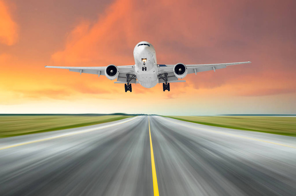 Samolot latający deperture lądowania prędkość ruchu na drodze startowej, wieczorem w jasny czerwony zachód słońca. - Zdjęcie, obraz