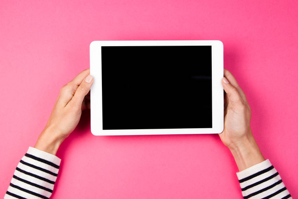 Womans hands with tablet computer on pink background. - Photo, Image