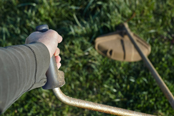 Closeup view of a grass trimmer in garden.  - Фото, изображение