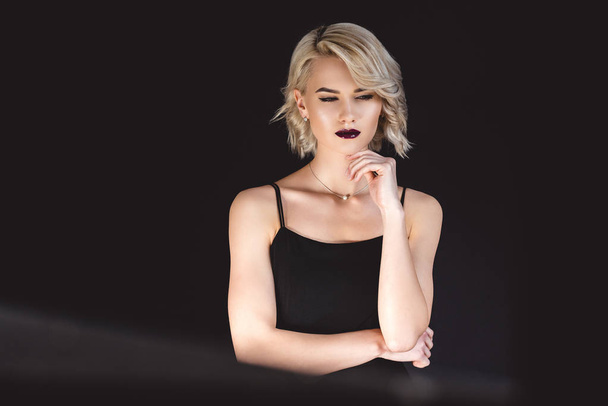 blonde girl posing in elegant black dress, isolated on black  - Foto, imagen