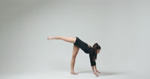 Girl wearing bodysuit standing on hands - Кадры, видео