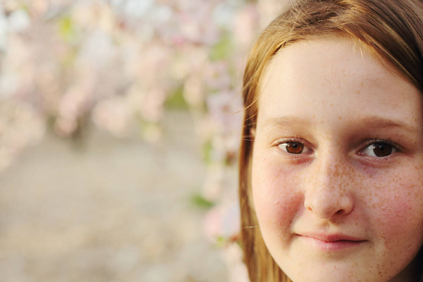 Ritratto ravvicinato di ragazza adolescente che cammina sul parco dei fiori rurale di giorno
 - Foto, immagini