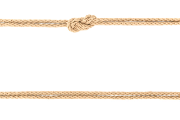 bovenaanzicht van gearrangeerde nautische touwen met knoop geïsoleerd op wit - Foto, afbeelding