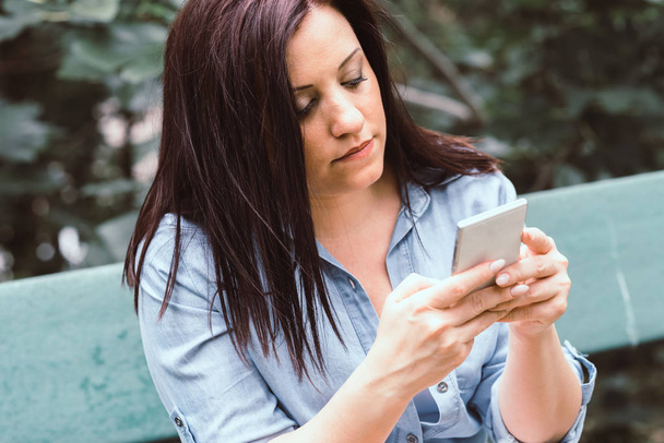 Portrait of young woman using her mobile phone - Photo, Image