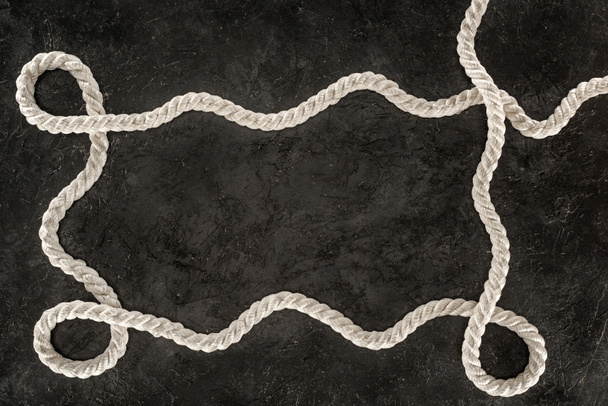 felülnézete a sötét konkrét asztali fehér tengeri kötél - Fotó, kép