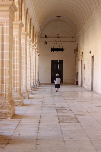 Old woman walking in abbey - Photo, Image