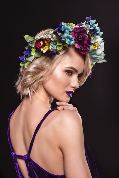 attractive blonde model posing in floral wreath, isolated on black - Photo, Image