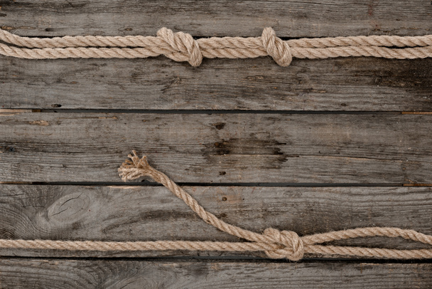 flat lay with marine ropes with knots on grunge wooden tabletop - Foto, immagini