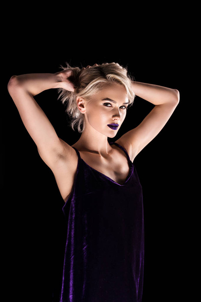 blonde girl posing in purple dress, isolated on black - Photo, Image
