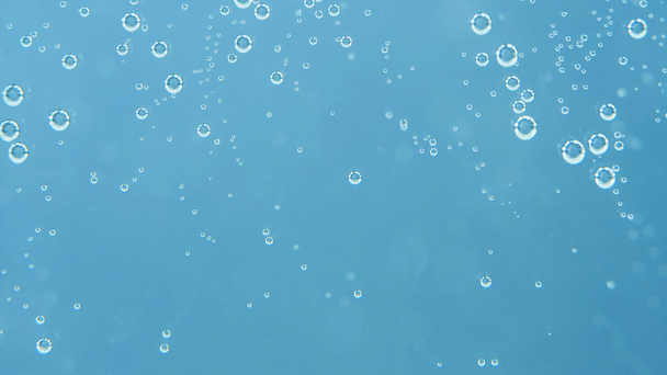 Absztrakt kék háttér. Felvétel, úszó víz buborékok, átlátszó falon keresztül. Friss víz fogalmát. - Felvétel, videó