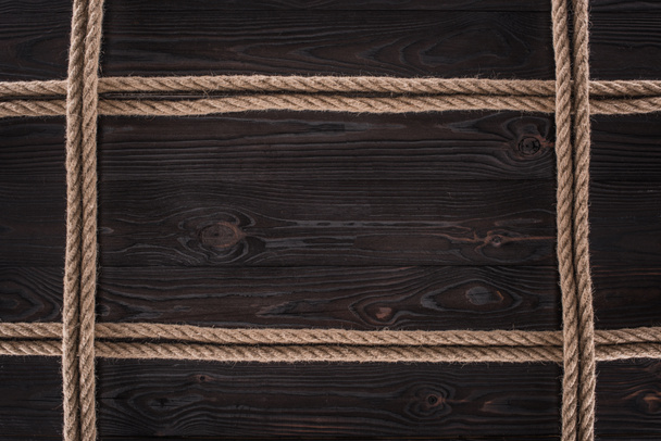 top view of arrangement of brown nautical ropes on dark wooden tabletop - Photo, Image