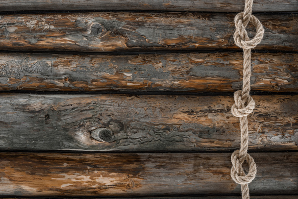 top view of nautical rope with knots on grunge wooden surface - Fotografie, Obrázek