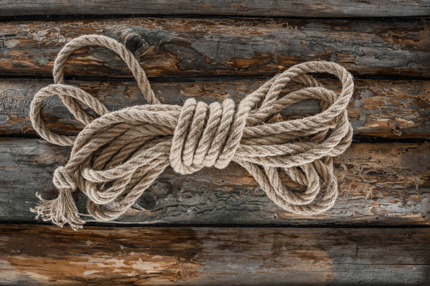 top view of tied nautical rope on grunge wooden surface - Zdjęcie, obraz