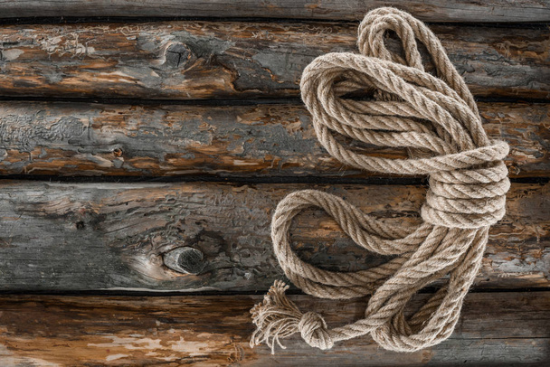 top view of tied nautical rope on grunge wooden surface - Foto, Imagen