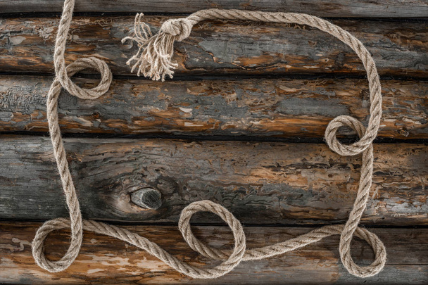 top view of nautical rope with knot on grunge wooden surface - Foto, immagini