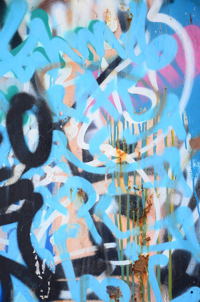 Szczegół fragment rysunek graffiti stosowane do ściany przez aerozolu farby. Ściana jest zepsuty przez mnóstwo kolorowych podpisów i Tagi od artystów ulicznych i chuliganów - Zdjęcie, obraz