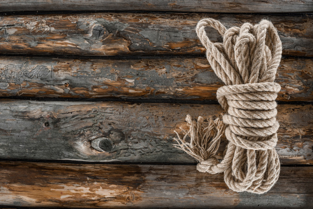 top view of tied nautical rope on grunge wooden surface - Zdjęcie, obraz