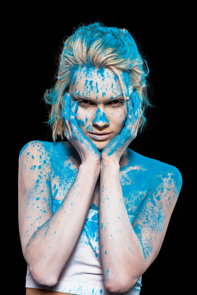 fiatal nő pózol kék szintézeres festéssel, elszigetelt fekete - Fotó, kép