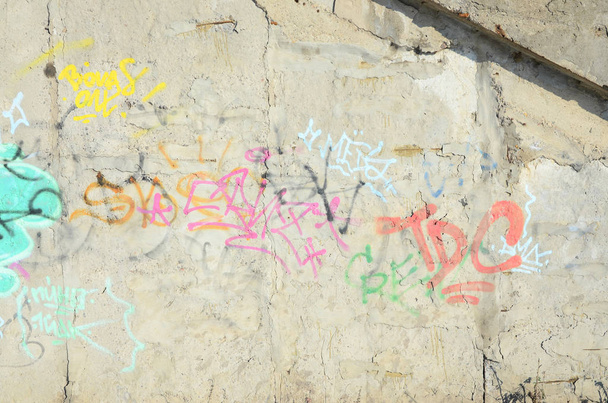 Крупним планом фрагмент графіті, нанесений на стіну аерозольною фарбою. Стіна псується безліччю різнокольорових підписів і міток від вуличних художників і хуліганів
 - Фото, зображення