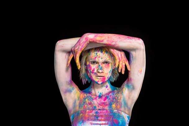 young stylish woman posing in colorful holi powder, isolated on black - Fotoğraf, Görsel
