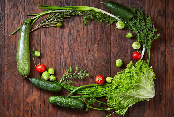 The round frame made of vegetables and herbs on a wooden background, copy space, top view - 写真・画像