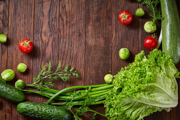Het ronde frame gemaakt van groenten en kruiden op een houten achtergrond, kopiëren ruimte, top uitzicht - Foto, afbeelding