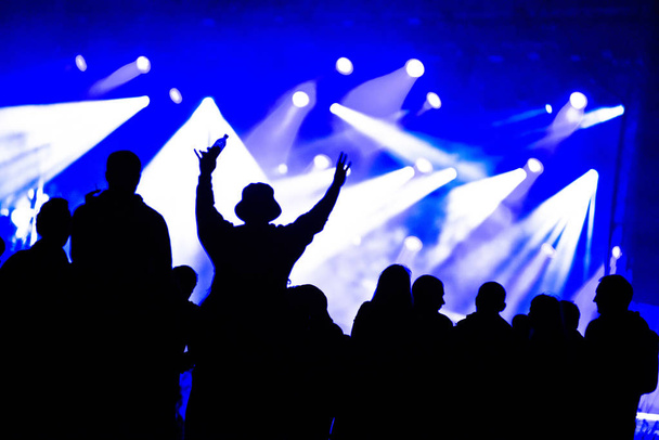 Silhouettes of concert crowd in front of stage lights - Fotografie, Obrázek