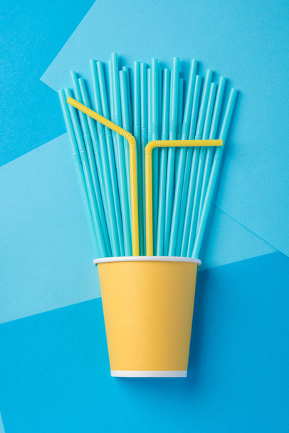 Palhas amarelas e azuis de um partido em xícaras de papel em um bac brilhante
 - Foto, Imagem