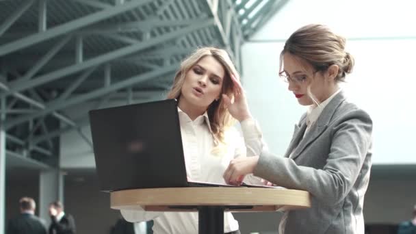 Καυκάσιες γυναίκες σε μια επαγγελματική συνάντηση. κορίτσι σε ρούχα επιχειρήσεων που εργάζονται με φορητό υπολογιστή - Πλάνα, βίντεο