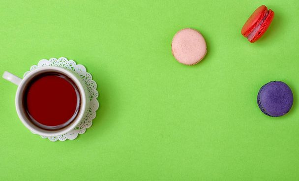 Colorful sweet macaroons and a cup of tea. Delicious breakfast. Top view. - Photo, image