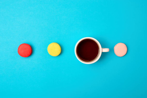 Colorful sweet macaroons and a cup of tea. Delicious breakfast. Top view. - Foto, immagini