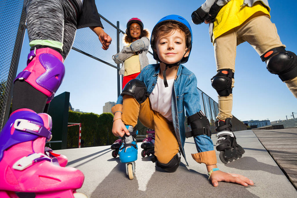 Écolier mignon en équipement de sécurité sur patins à roulettes à l'extérieur
 - Photo, image