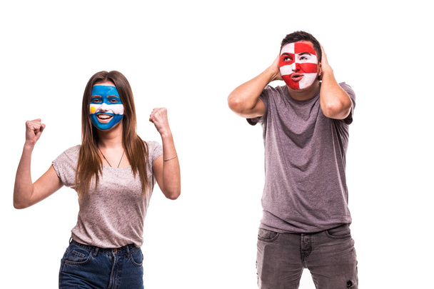 Футбольные болельщики Аргентины празднуют победу над расстроенным футбольным фанатом Хорватии с нарисованным лицом на белом фоне
 - Фото, изображение