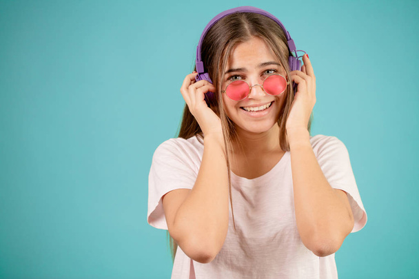 teenage with grey eyes touching her headphones on her head - Φωτογραφία, εικόνα