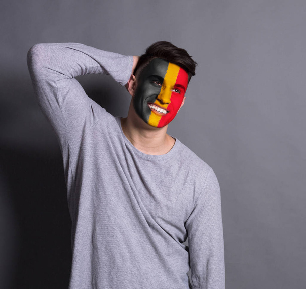 Jeune homme avec le drapeau belge peint sur son visage
 - Photo, image