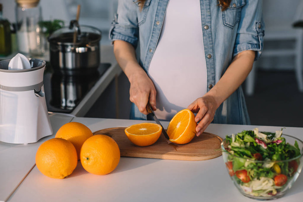 pregnant cutting oranges - 写真・画像
