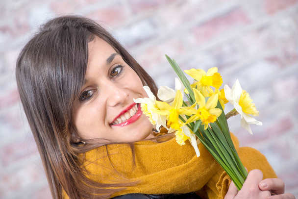 young brunette woman with bouquet of daffodils - Fotografie, Obrázek