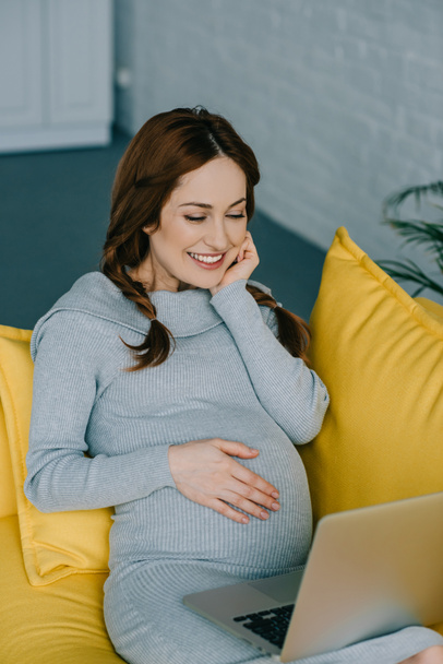 Pregnant  looking at laptop - Фото, зображення