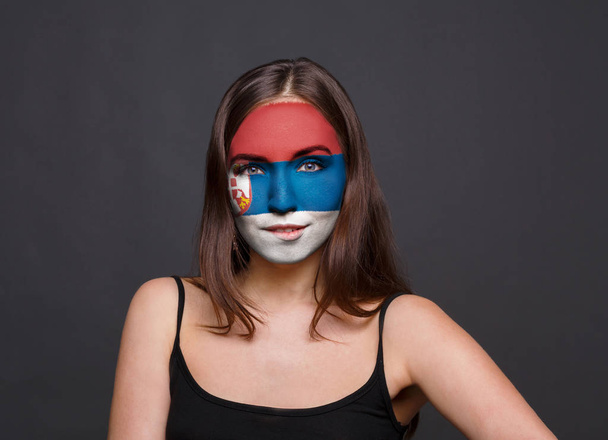 Jonge vrouw met Servië vlag geschilderd op haar gezicht - Foto, afbeelding