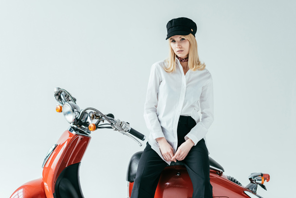 Atractiva joven sentada en motocicleta vintage aislada en gris
 - Foto, Imagen