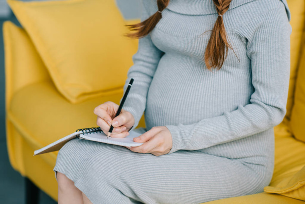 pregnant woman writing - Foto, afbeelding