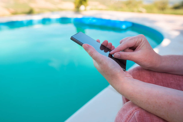 Pomocí mobilního telefonu u bazénu - Fotografie, Obrázek