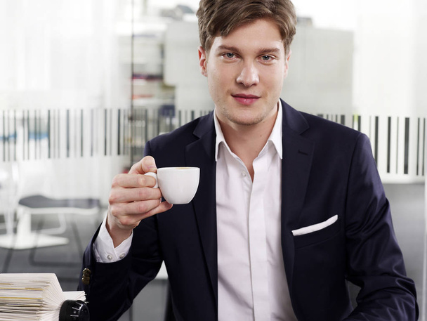 Businessman at desk with coffee - Foto, afbeelding